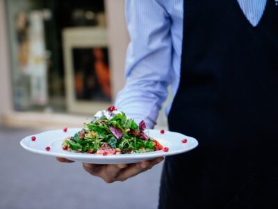 person holding a plate of salad